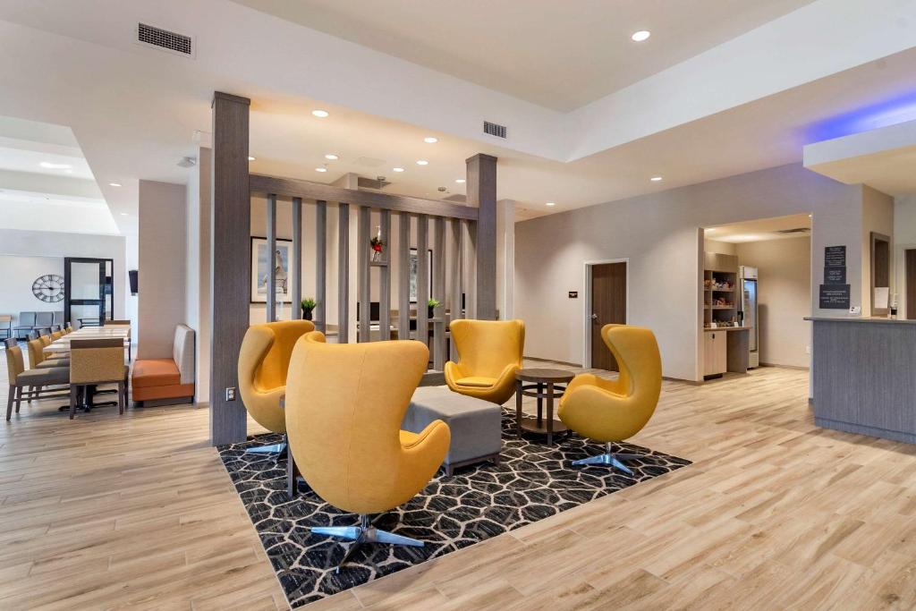 una sala de espera con sillas amarillas y una mesa en Comfort Suites Grandview - Kansas City, en Grandview