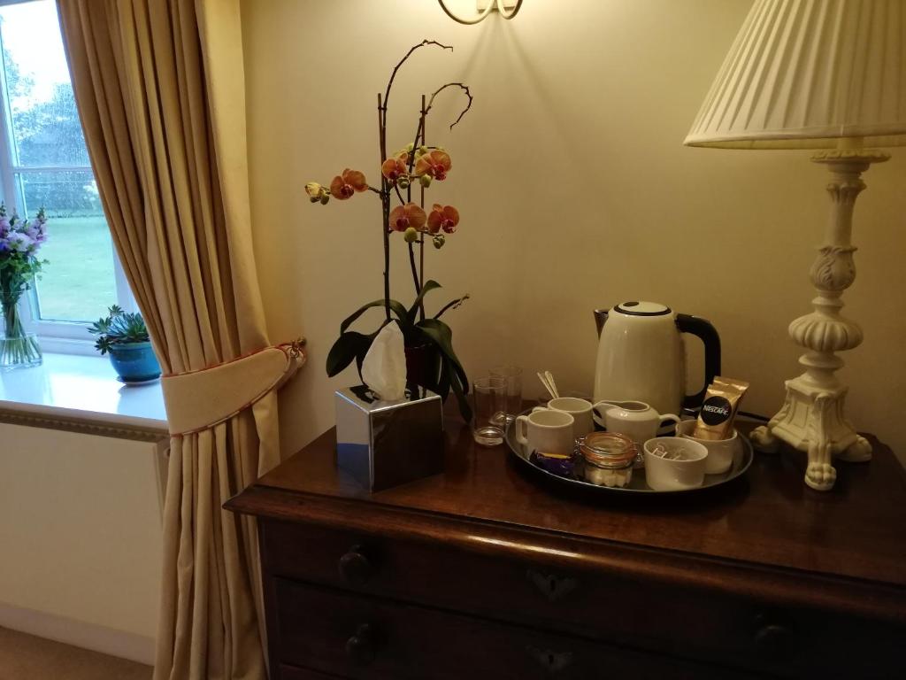 una mesa con una bandeja de tazas de café y flores. en Rusling House, en Bristol