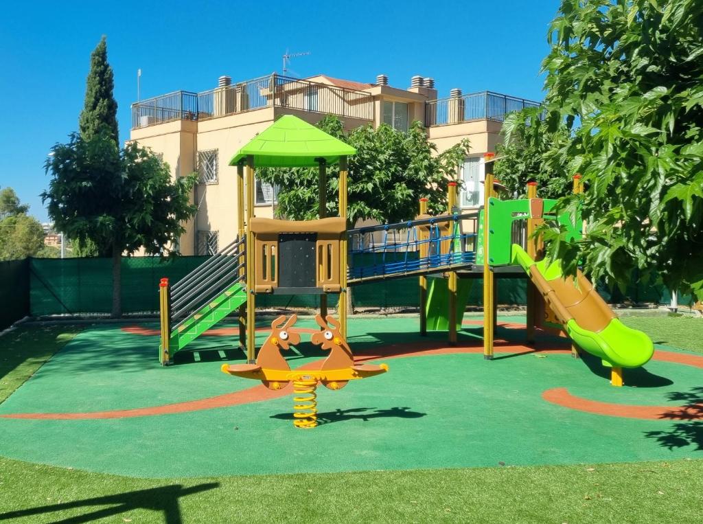 a playground in a park with a slide at Apartaments Els Llorers in Lloret de Mar