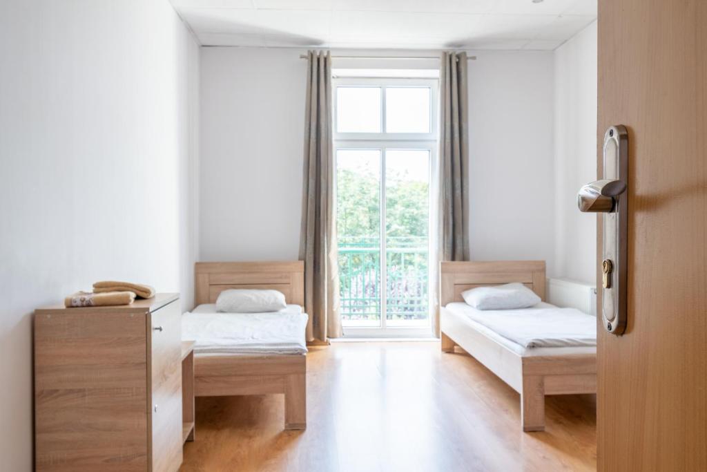 カトヴィツェにあるホステル カトヴィツェ セントラムのベッドルーム1室(ベッド2台、窓付)
