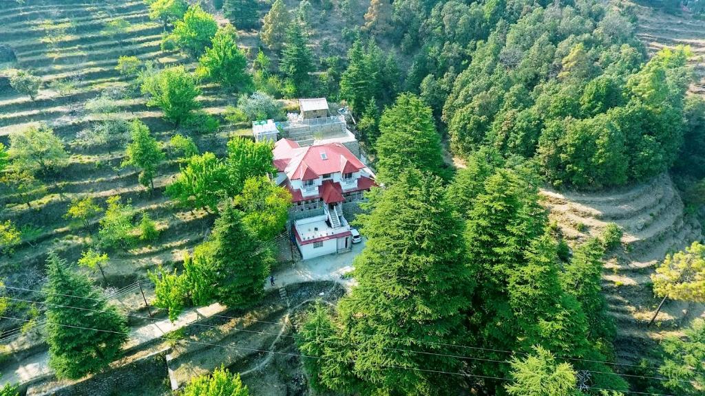 una vista aérea de una casa con techo rojo en Vibhasa-Dhaulagiri Room in Adventure Bliss Villa Where Scenic Views Meet BBQ and Bonfire Delights en Rāmgarh