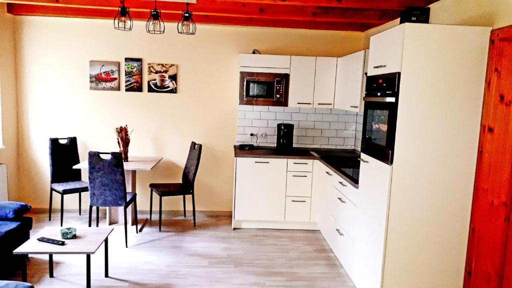 a kitchen with white cabinets and a table and chairs at Staar in Hohenfelde