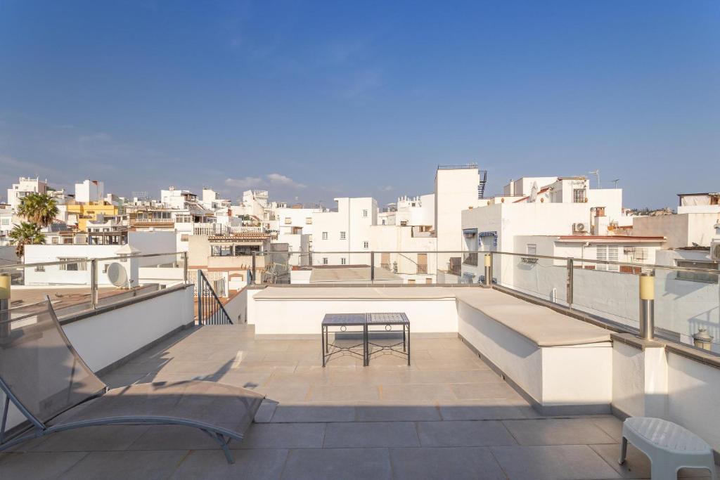 Un balcón con una mesa y vista a una ciudad. en Casa Familiar 8 personas, en Almuñécar