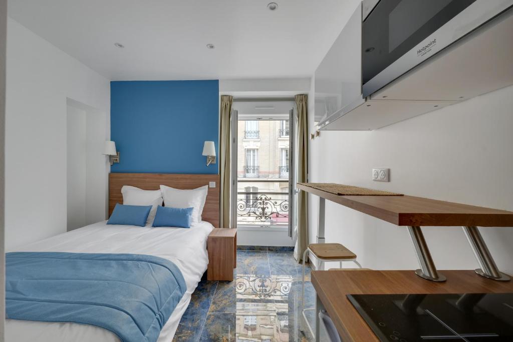 a hotel room with a bed and a television at Le Bellevue in Paris