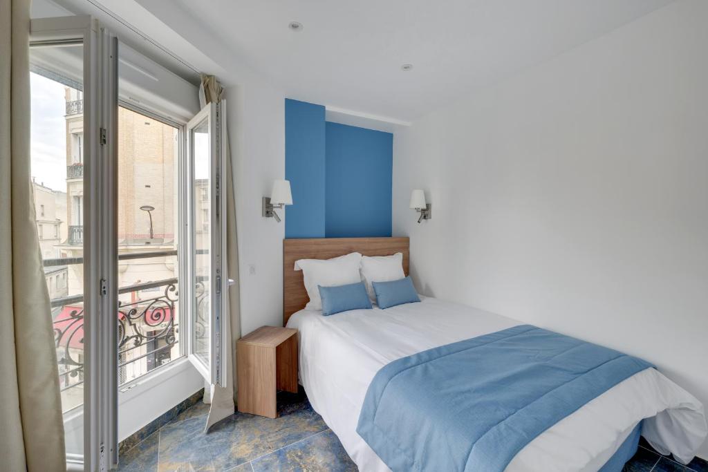 a bedroom with a bed and a balcony at Le Bellevue in Paris