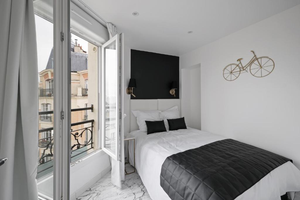 a bedroom with a bed and a large window at Le Bellevue in Paris