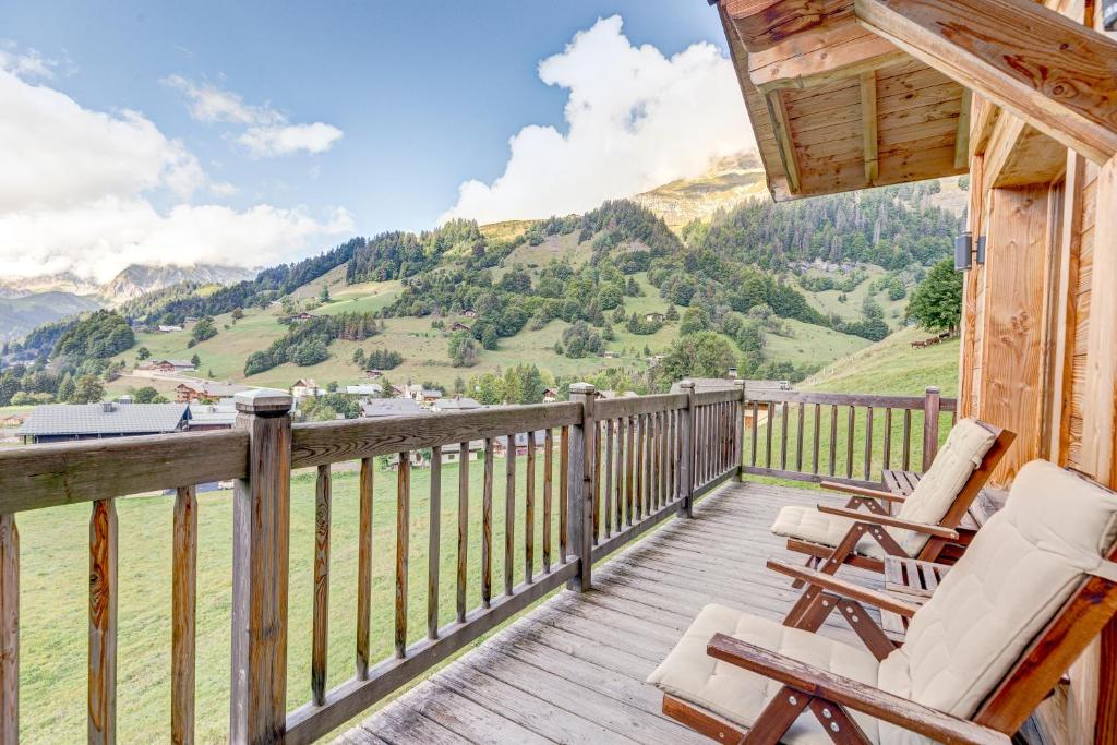d'une terrasse avec des chaises et une vue sur les montagnes. dans l'établissement Le Chalet Blanc, à La Giettaz