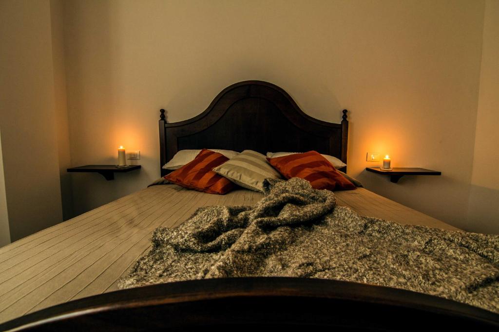 1 dormitorio con 1 cama con 2 velas en la pared en Campo Felice Experience en Rocca di Cambio