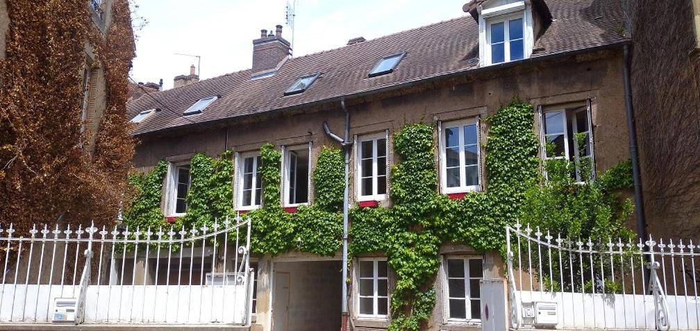 a house with ivy growing on the side of it at Gite de l'Arbalète in Autun