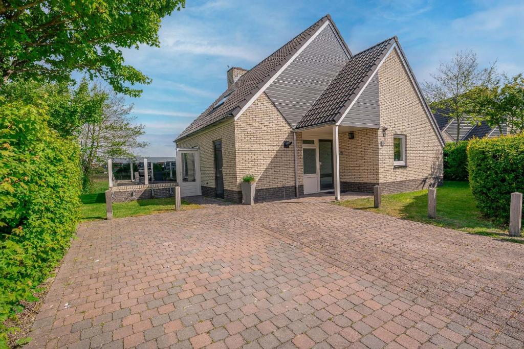 una casa con una entrada de ladrillo delante de ella en Villapark Kamperfoelie 69, en De Koog