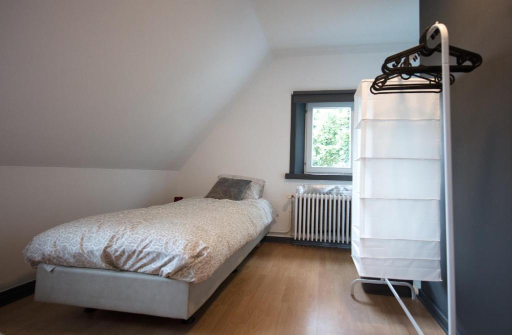 a bedroom with a bed and a book shelf at Logies De Witte Hoeve in Oudenaarde
