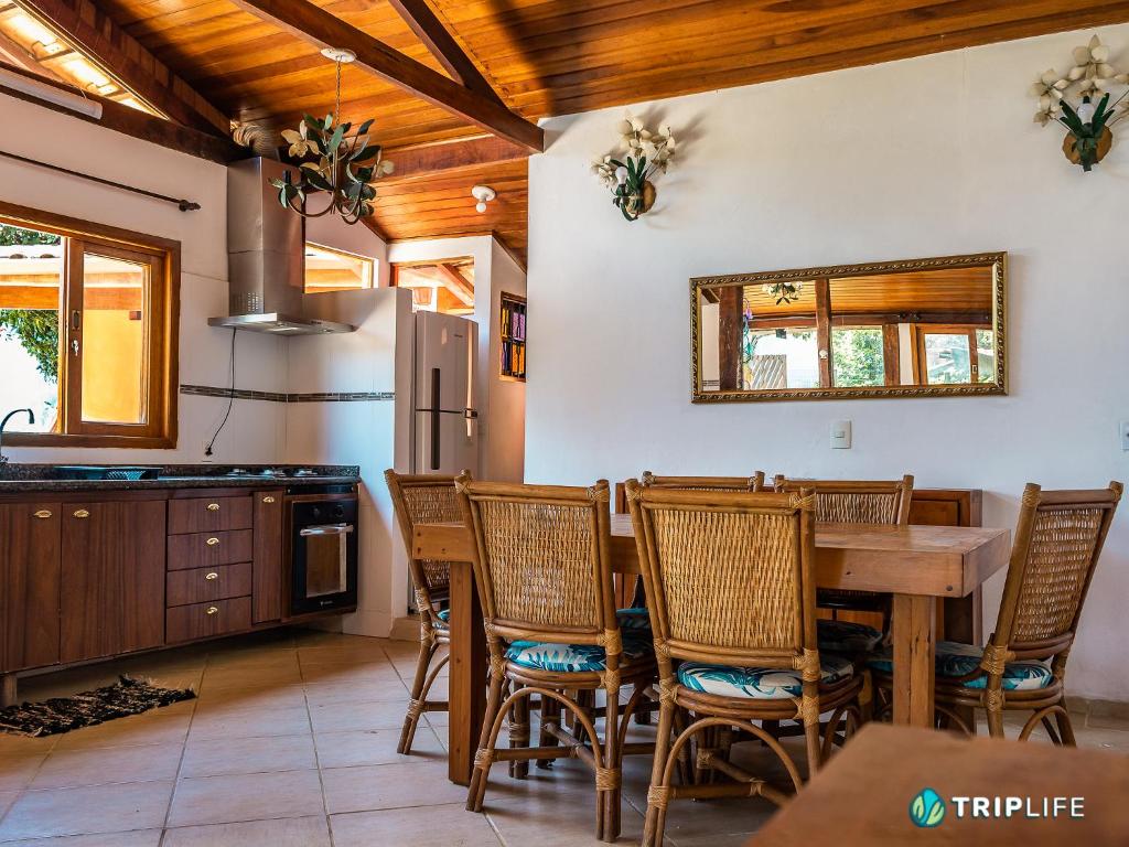 uma cozinha com uma mesa e cadeiras e um frigorífico em Casa Mandalê em Ilhabela