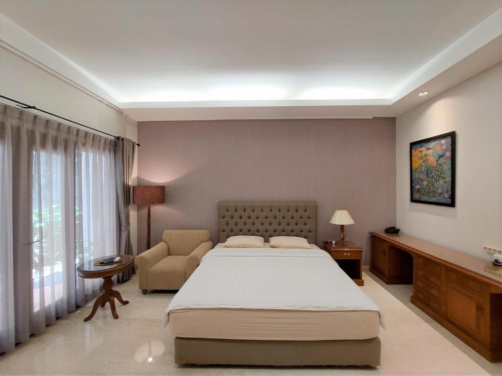 sypialnia z łóżkiem, krzesłem i oknem w obiekcie Via Renata Prapanca w Dżakarcie