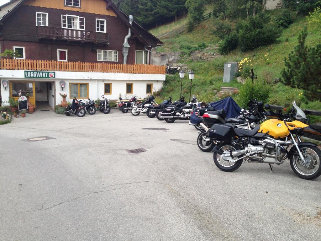 rząd motocykli zaparkowany przed budynkiem w obiekcie Gasthaus Luggwirt w mieście Gnesau