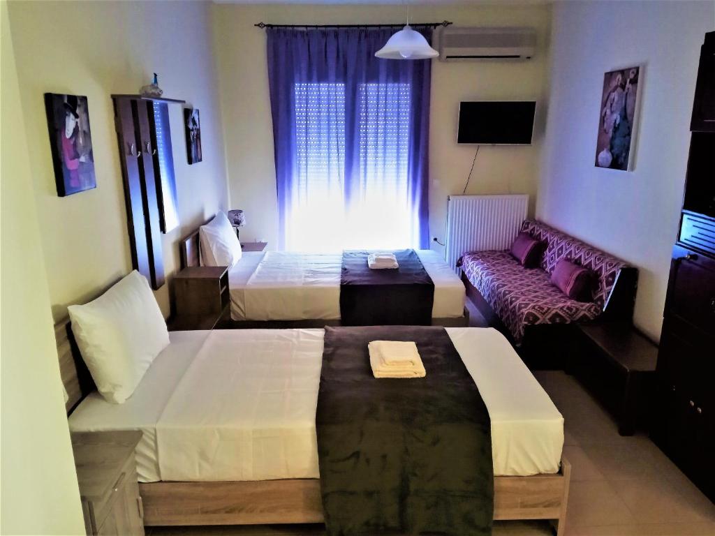 um quarto de hotel com duas camas e um sofá em Alkioni City Apartments em Chania