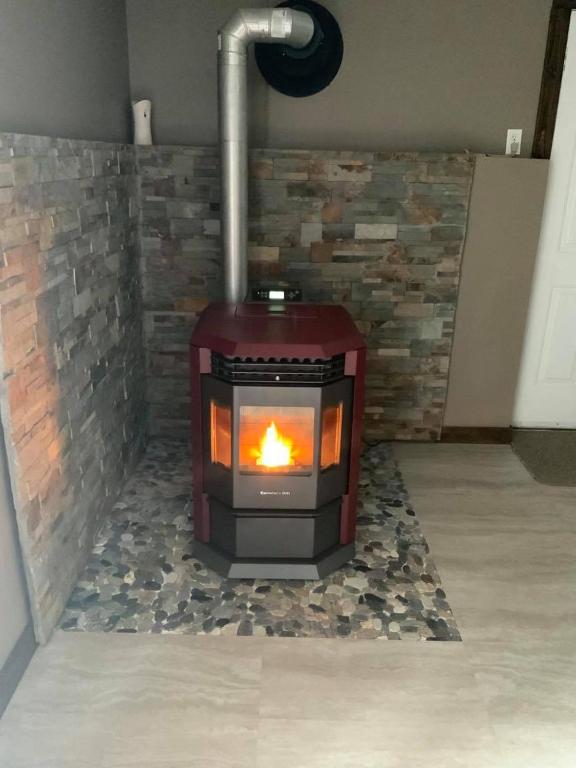 a fireplace in a room with a brick wall at Suite in the Bush-Private Apartment in Bancroft