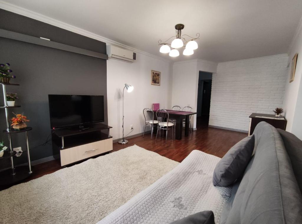 a living room with a couch and a flat screen tv at Nadezhda Apartments on Nayryzbay batyr 82 in Almaty