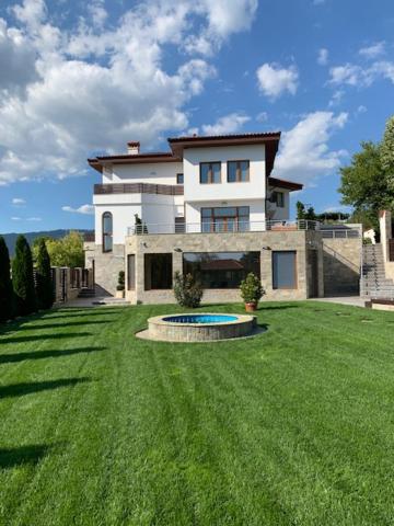 una casa grande con piscina en el patio en Луксозна вила - Стрелча, джакузи с минерална вода, en Strelcha