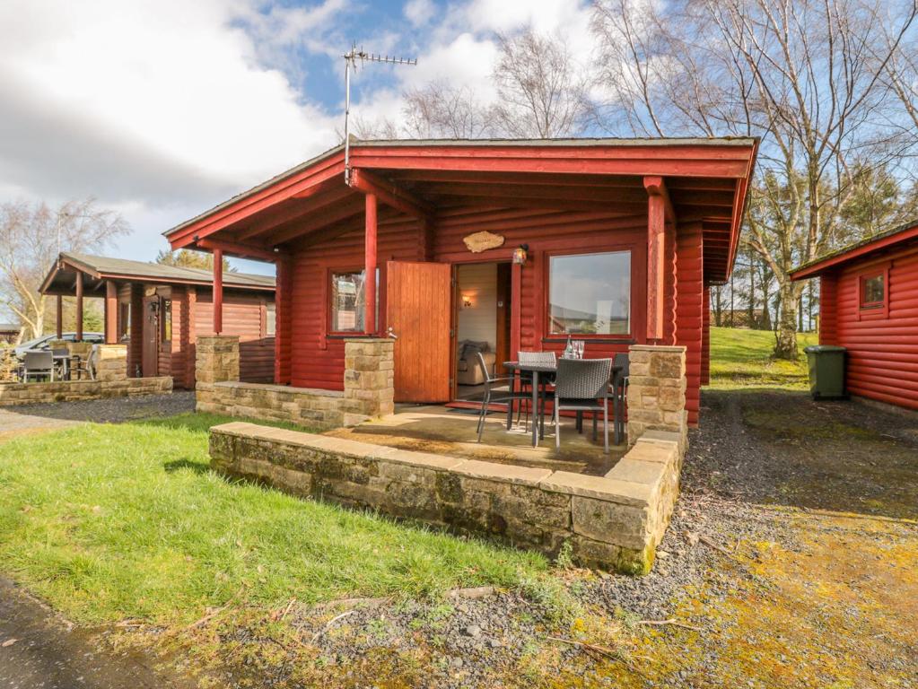 a log cabin with a table in front of it at Ingram in Morpeth