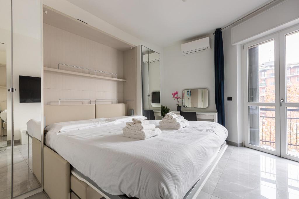 a bedroom with a large white bed with towels on it at BnButler - Largo Promessi Sposi - Moderno e Confortevole in Milan