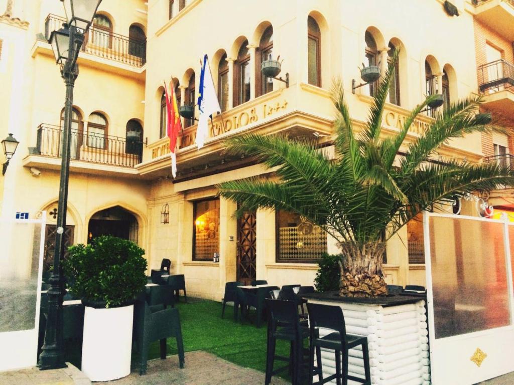 a restaurant with a palm tree in front of a building at Hotel Juan Carlos I in Villarrobledo