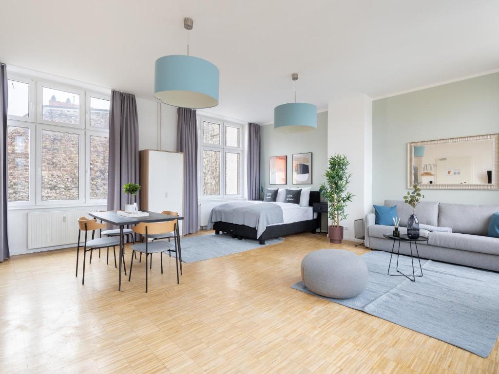 a living room with a couch and a bed and a table at limehome Berlin Neue Straße in Berlin