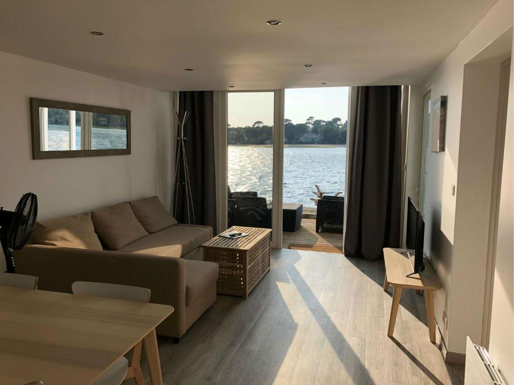 a living room with a couch and a tv at Appartement Du Lac in Hossegor
