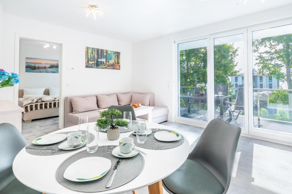 a white living room with a white table and chairs at Apartment "Haffblick" - Haffresidenz in Garz