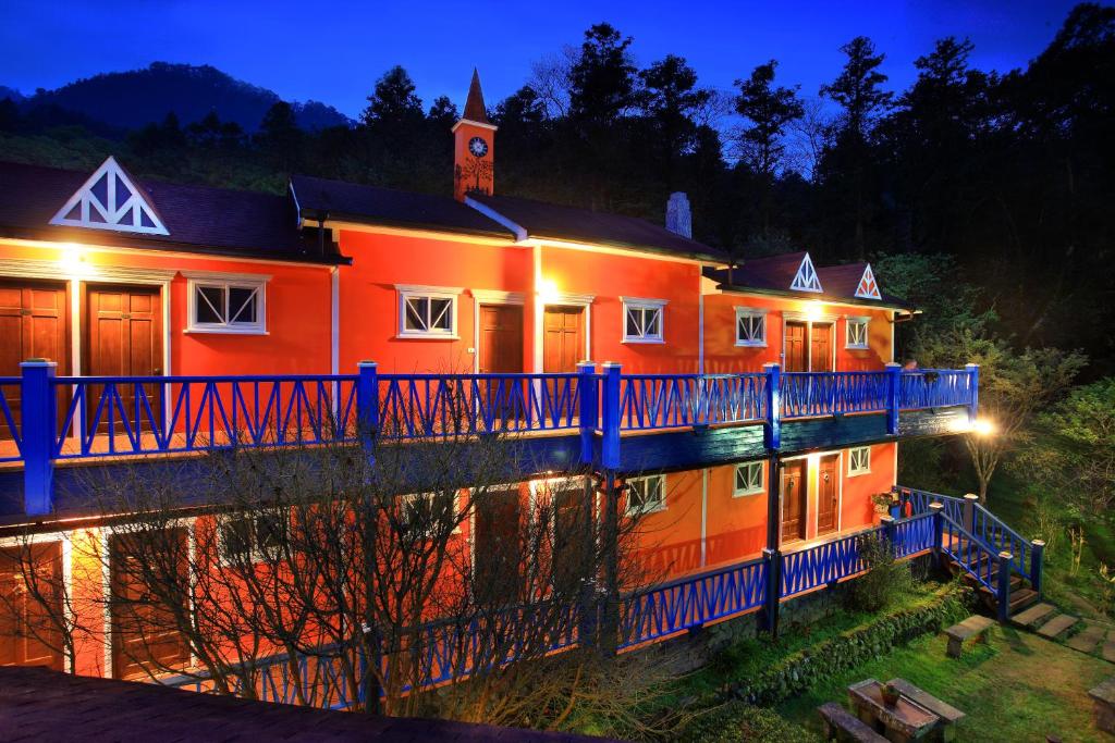 an orange house with a blue fence around it at night at Li Jin Kuan Homestay in Nanzhuang