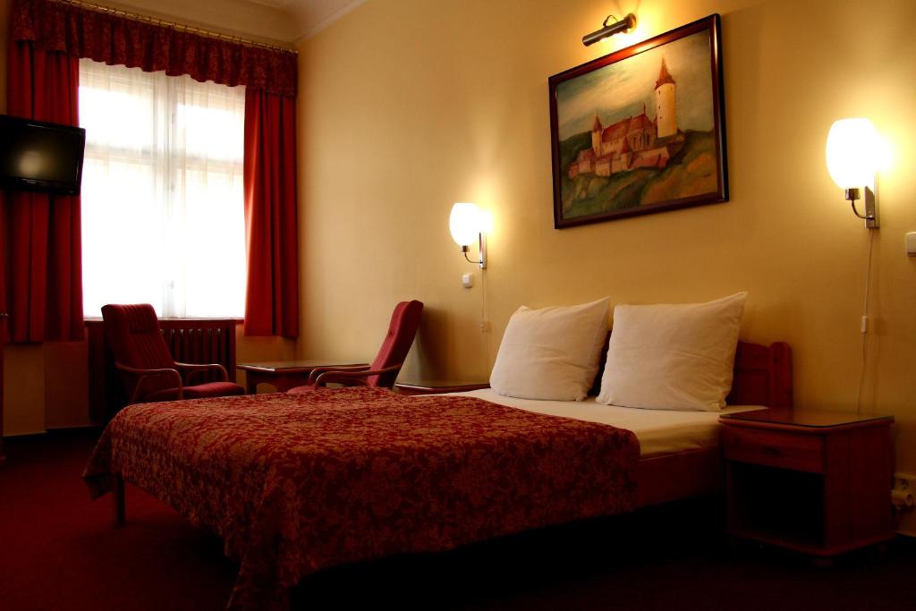Habitación de hotel con cama con almohadas blancas en Unitas Residence en Praga