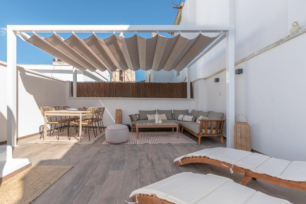 a patio with a couch and a table at Attic Oasis in Málaga