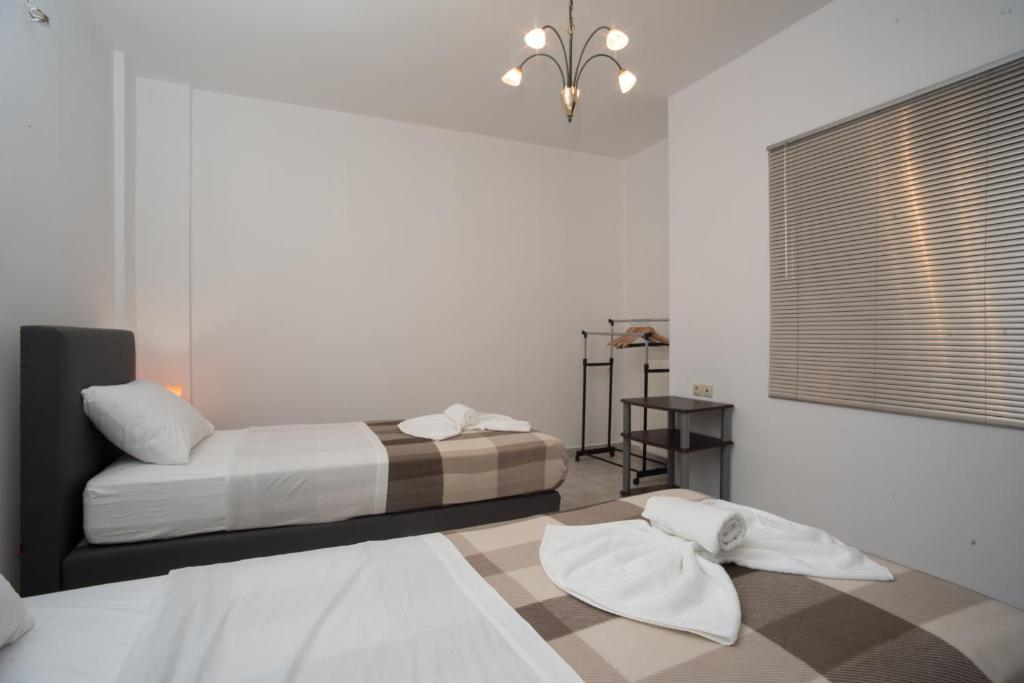 sypialnia z 2 łóżkami i żyrandolem w obiekcie Olive Green Suite w mieście Ligaria