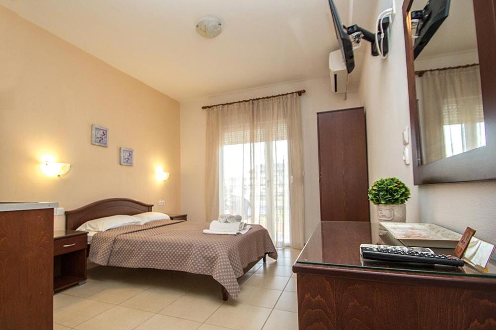 a hotel room with a bed and a desk in it at Denis Studios and Apartments in Paralia Katerinis