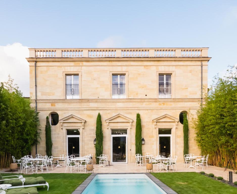 - un bâtiment avec une piscine en face dans l'établissement Hôtel Maison Pavlov, à Le Bouscat