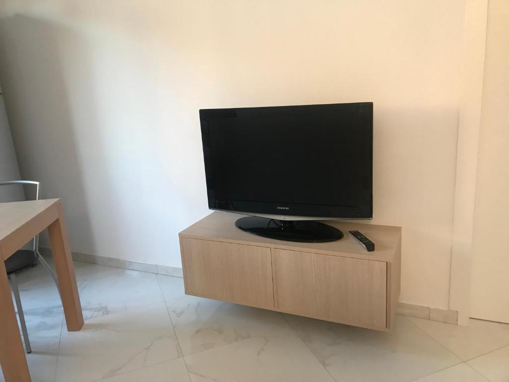 TV de pantalla plana en la parte superior de un armario de madera en Erika modern apartment in Brianza, en Vimercate