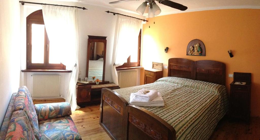 1 dormitorio con 1 cama grande y espejo en Aurora B&B, en Cividale del Friuli