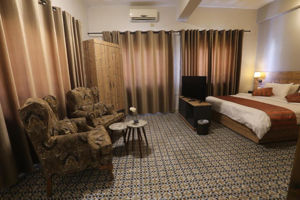 ein Hotelzimmer mit einem Bett und einem Stuhl in der Unterkunft Riviera Hotel in Amman