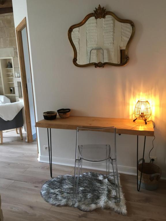 a table with a lamp and a mirror on a wall at Vieux Tours, Charmant T2 40m2, 4 pers, lumineux in Tours