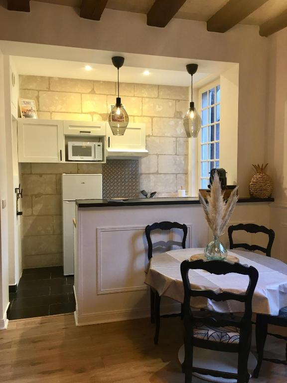 a kitchen with a table with chairs and a microwave at Vieux Tours, Charmant T2 40m2, 4 pers, lumineux in Tours