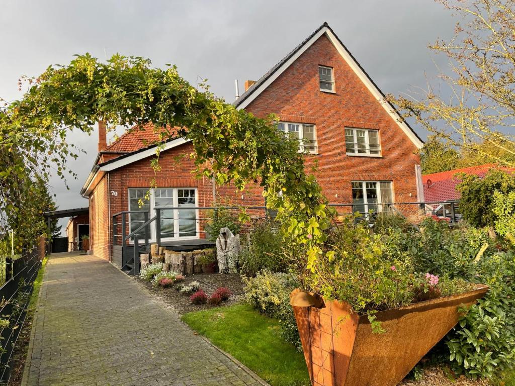 a brick house with a garden in front of it at Freimuth`s Hof in Südbrookmerland