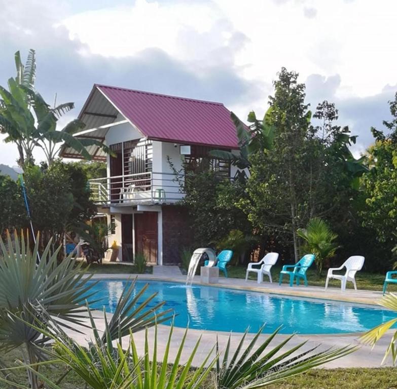 Villa con piscina frente a una casa en Rancho Colorado, en Pitalito