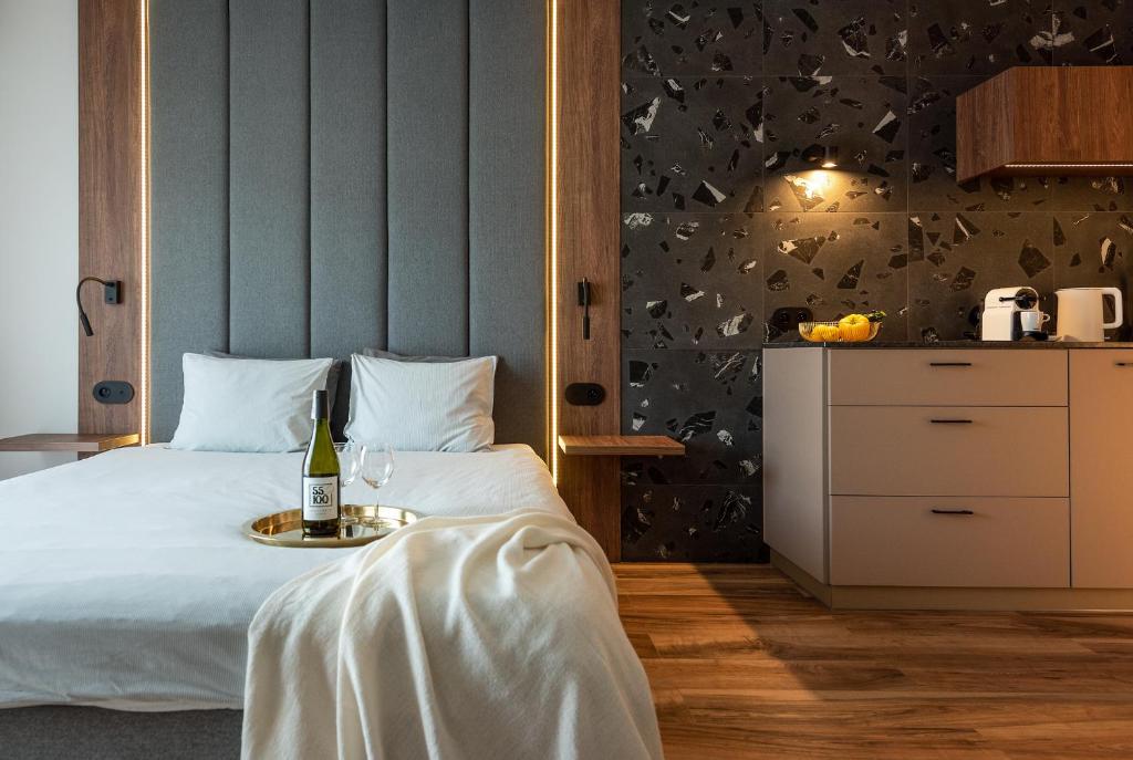 a bedroom with a bed with a bottle of wine at apartamenty-wroc Kurkowa in Wrocław