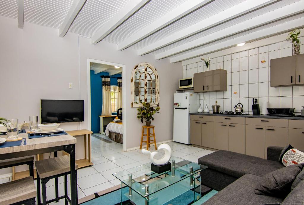 uma cozinha e sala de estar com um sofá e uma mesa em CityLife Apartments in Willemstad - groundfloor 2 bedroom apartment - C em Willemstad