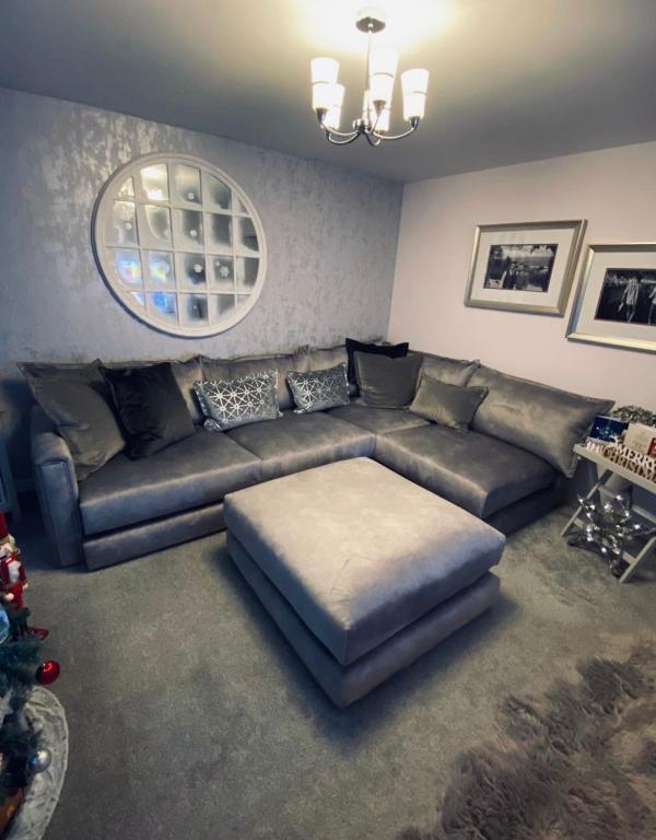 a living room with a couch and a mirror at Cop26 3 bedroom house - 10mins walk GLA Airport in Paisley