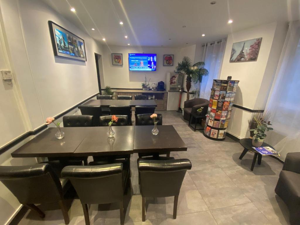 a room with a table and chairs and a television at Residence Chatillon in Paris