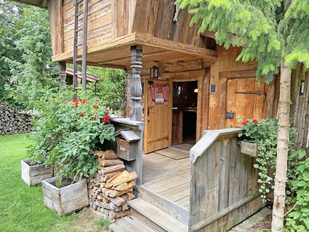 a wooden house with a porch and a door at Bayerisches Refugium mit Sauna in Tittmoning