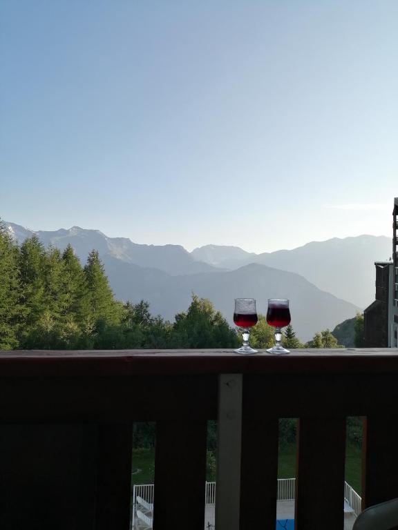 - deux verres de vin assis sur le balcon dans l'établissement Les Bergers Alpe d'Huez Pied des pistes et piscine, à Huez