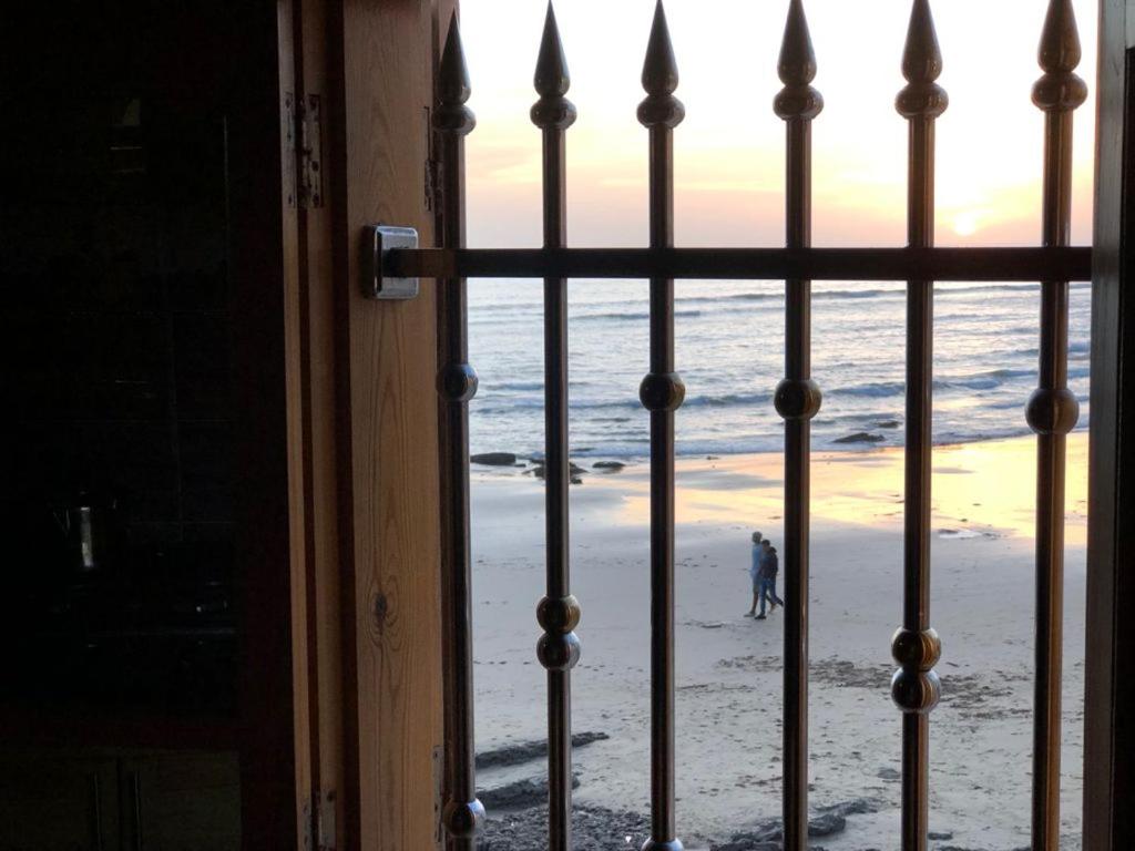 a view of the beach from a window of a door at beachfront house in Taghazout