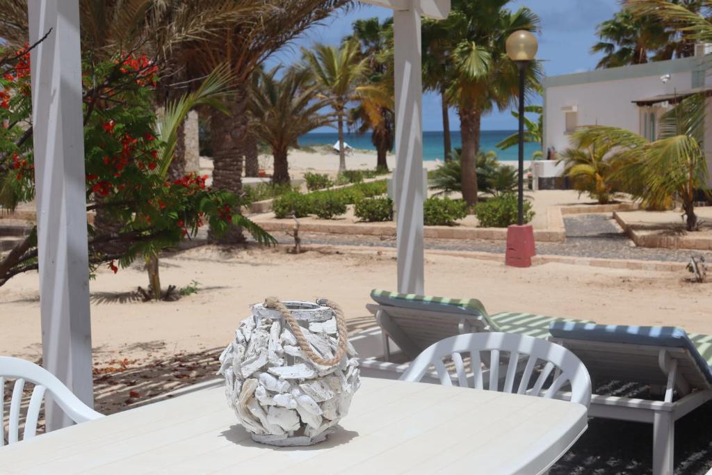 einen Tisch mit einer Vase darüber am Strand in der Unterkunft Sea view sol & mar in Rabil