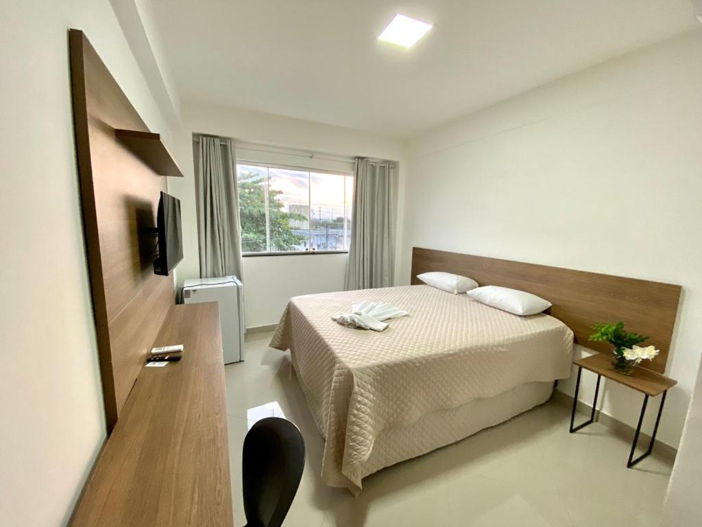 Habitación de hotel con cama y ventana en Hotel Skalla, en Teixeira de Freitas
